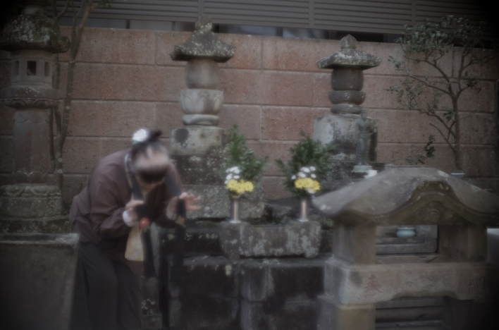 In front of Kichi's grave in Houfukuji, local storyteller Yoko Yugao poignantly recounts Kichi's life.